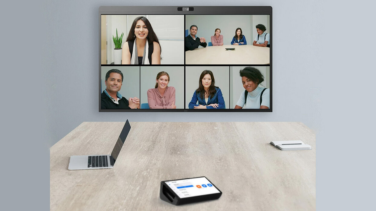 Sicht vom Konferenztisch auf das D7X Whiteboard, auf dem Tisch stehen ein Laptop und ein Touch Controller