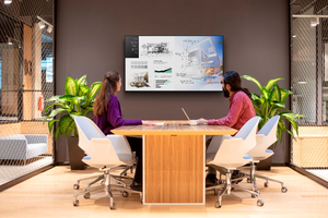 Zwei Personen sitzen in einem Konferenzraum und halten ein Meeting ab, das SONY BRAVIA BZ340H wird als Anzeigedisplay genutzt
